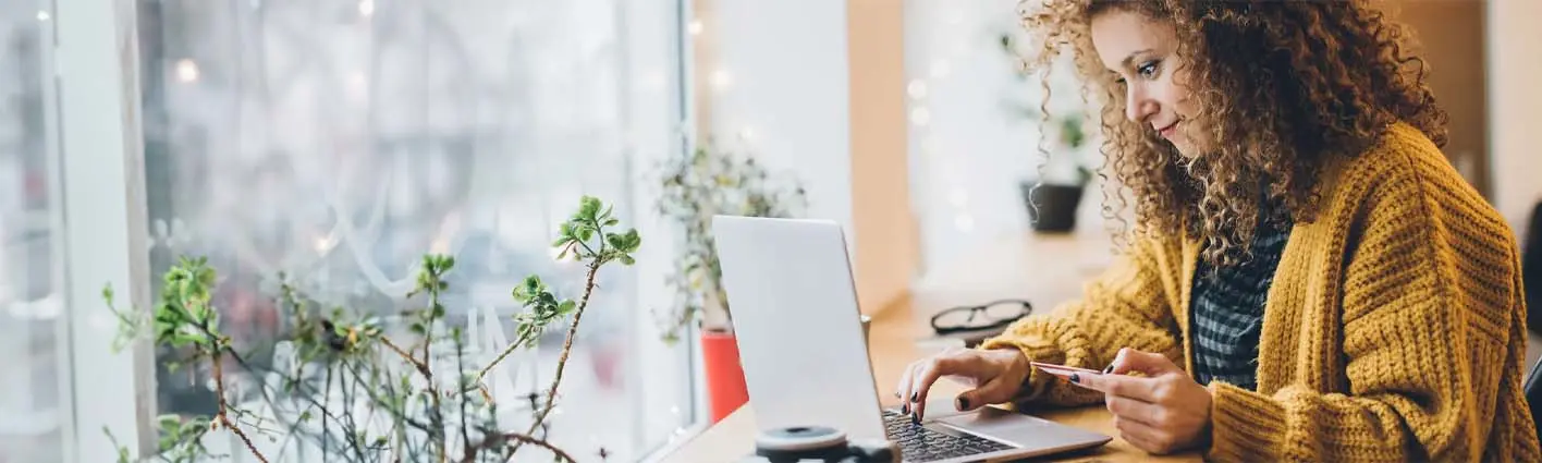A woman sitting at a table using a laptop.