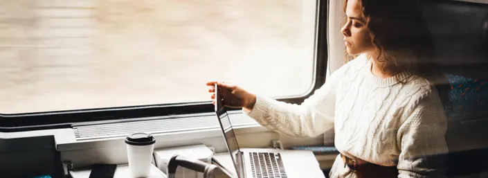 Fille dans un train avec un ordinateur portable