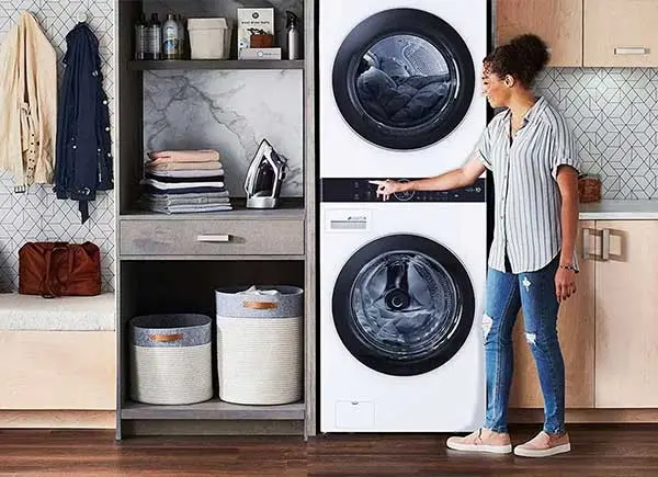 Une femme à côté d'un sèche-linge.
