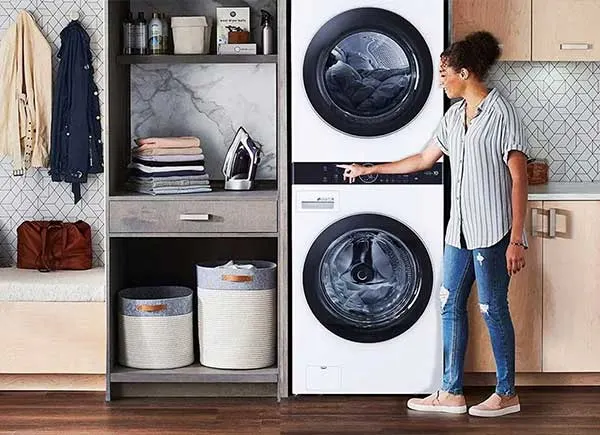Une femme à côté d'un sèche-linge.