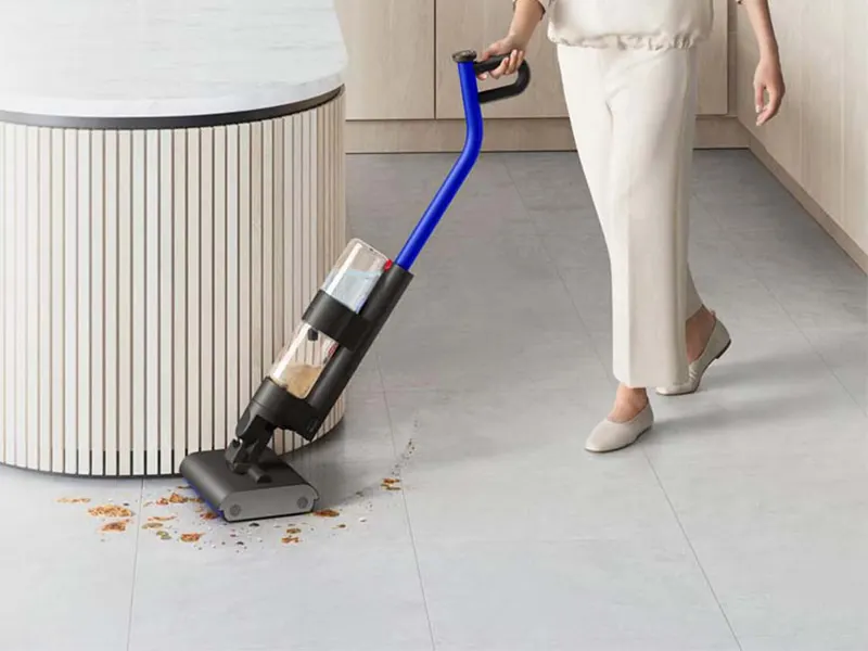 Une utilisatrice nettoyant un sol dur avec le Dyson WashG1 dans un grand espace de vie