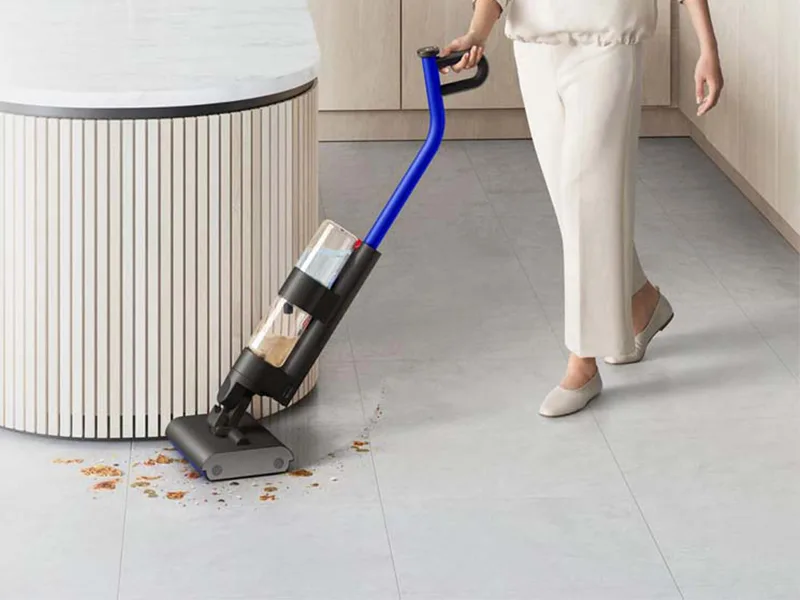 Une utilisatrice nettoyant un sol dur avec le Dyson WashG1 dans un grand espace de vie