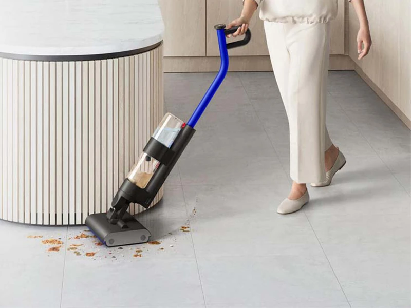 Een gebruiker reinigt een harde vloer in een grote woonkamer met de Dyson WashG1