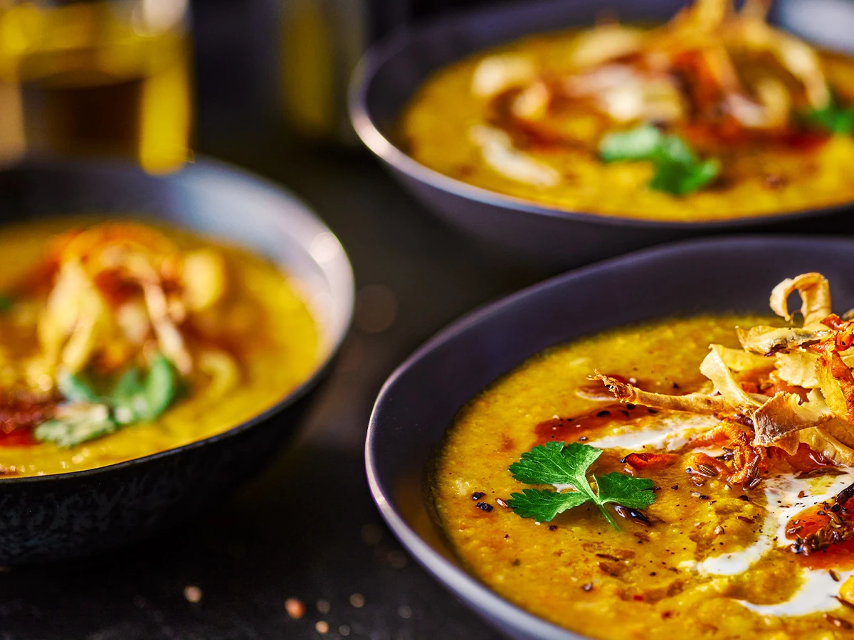 Three bowls of carrot soup