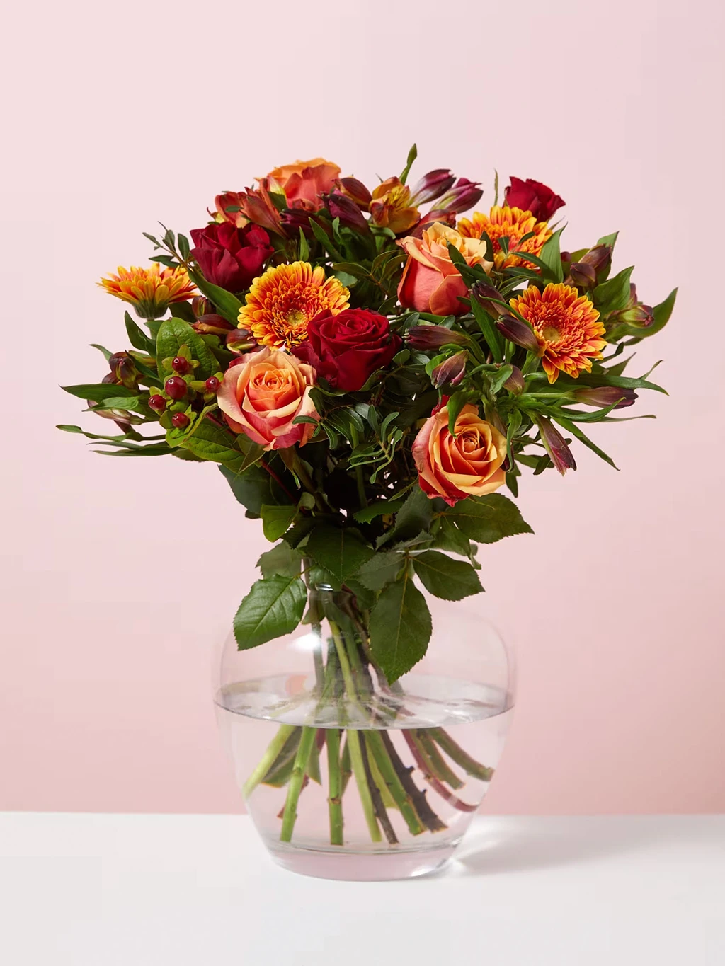 Autumnal-toned bouquet in glass vase