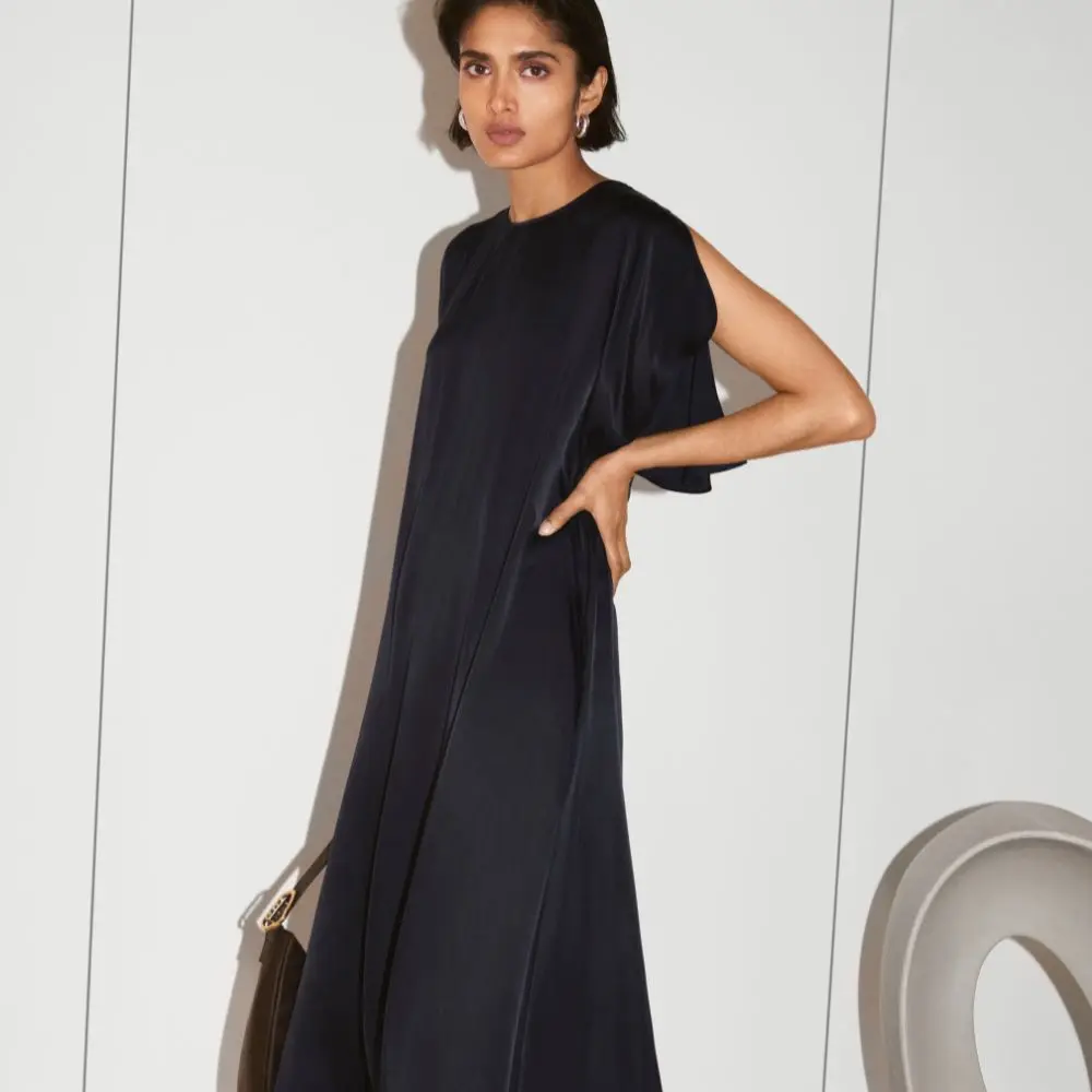 A woman wears a long flowy navy dress