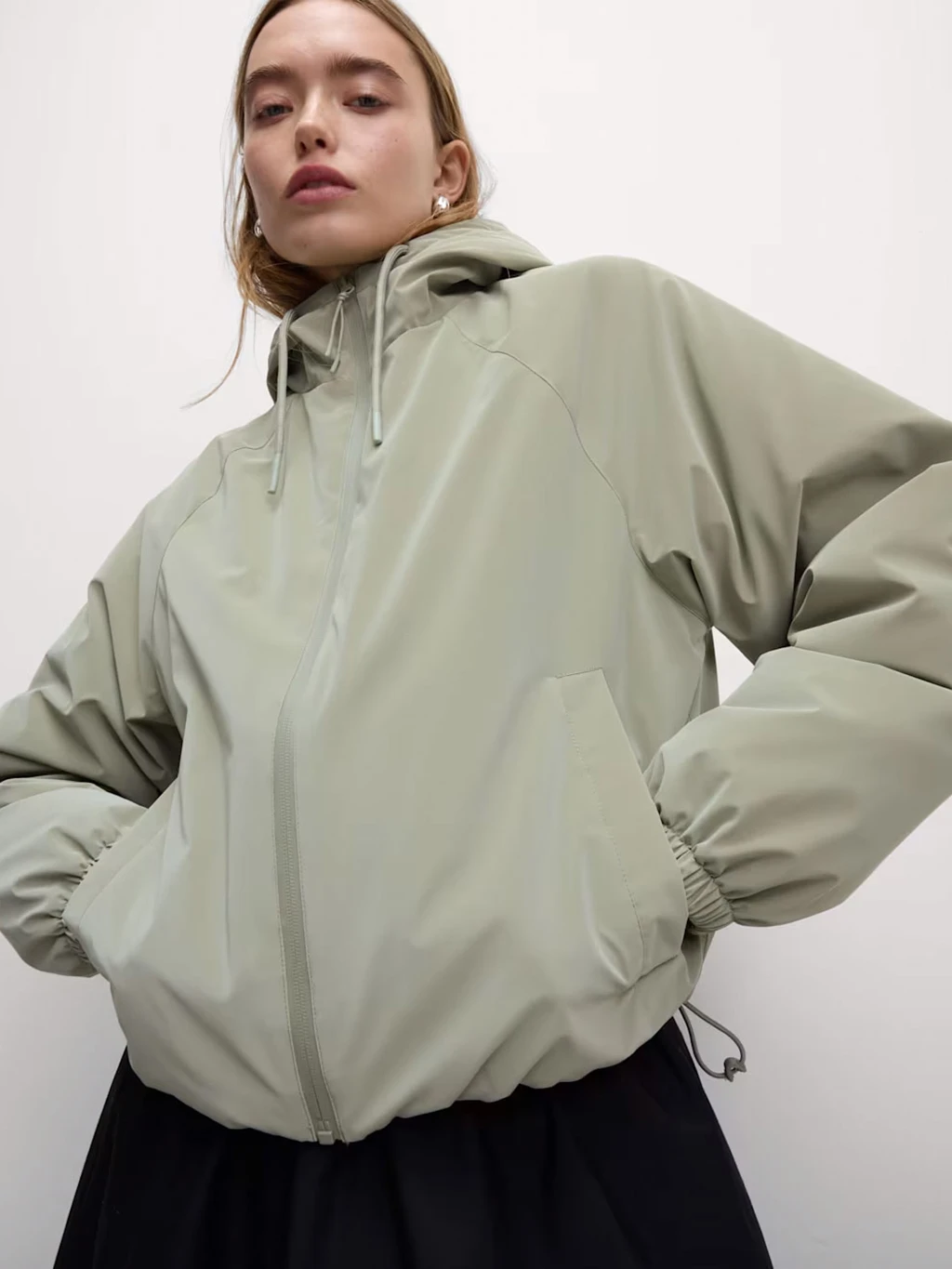 Woman wearing light green waterproof bomber jacket 