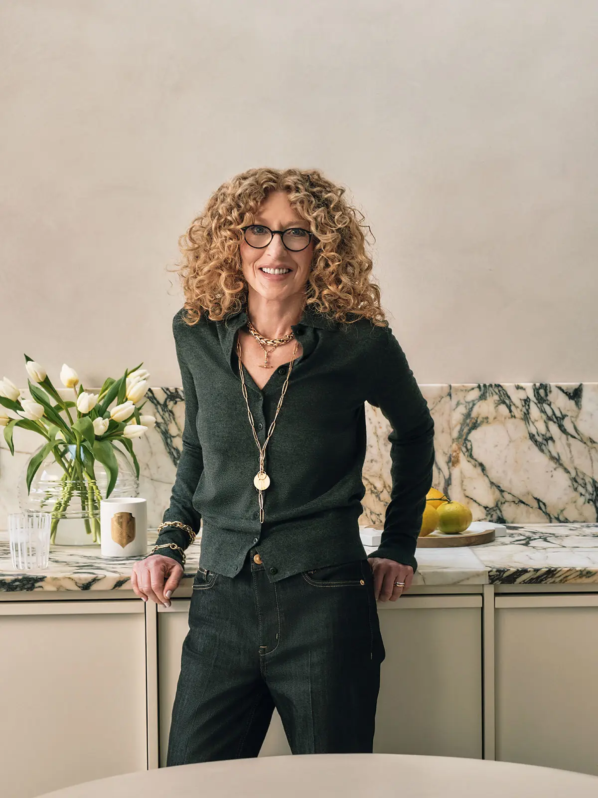 Kelly Hoppen wearing dark green cardigan and jeans 