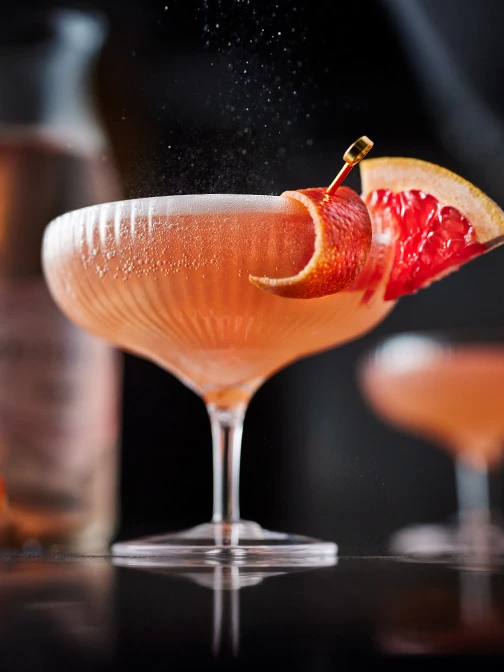 Cocktail in coupe glass with slice of grapefruit