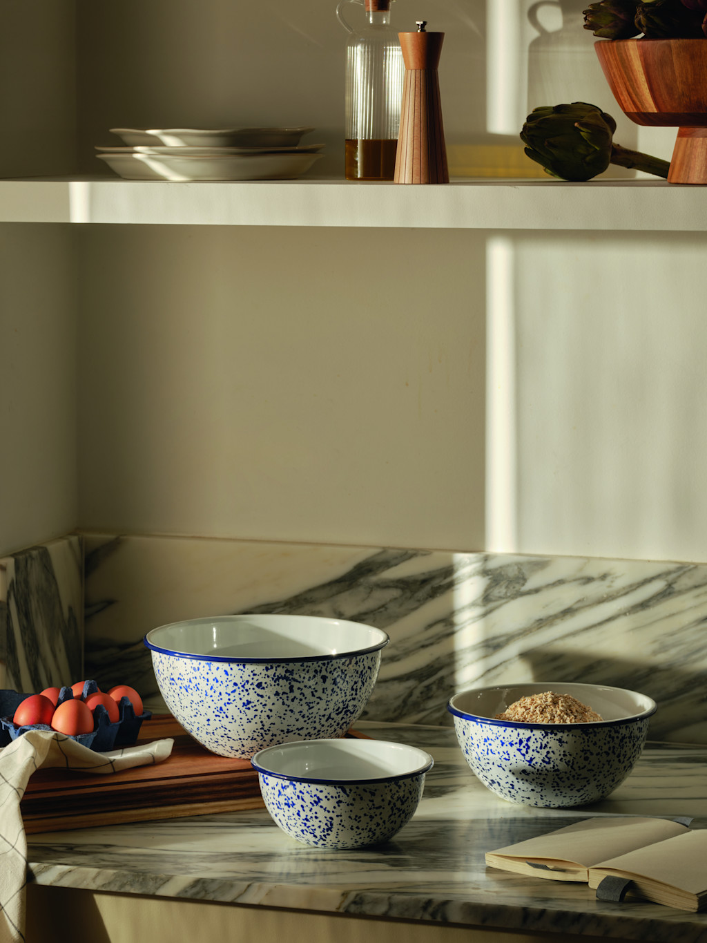 Neutral kitchen with mixing bowls on marble countertop