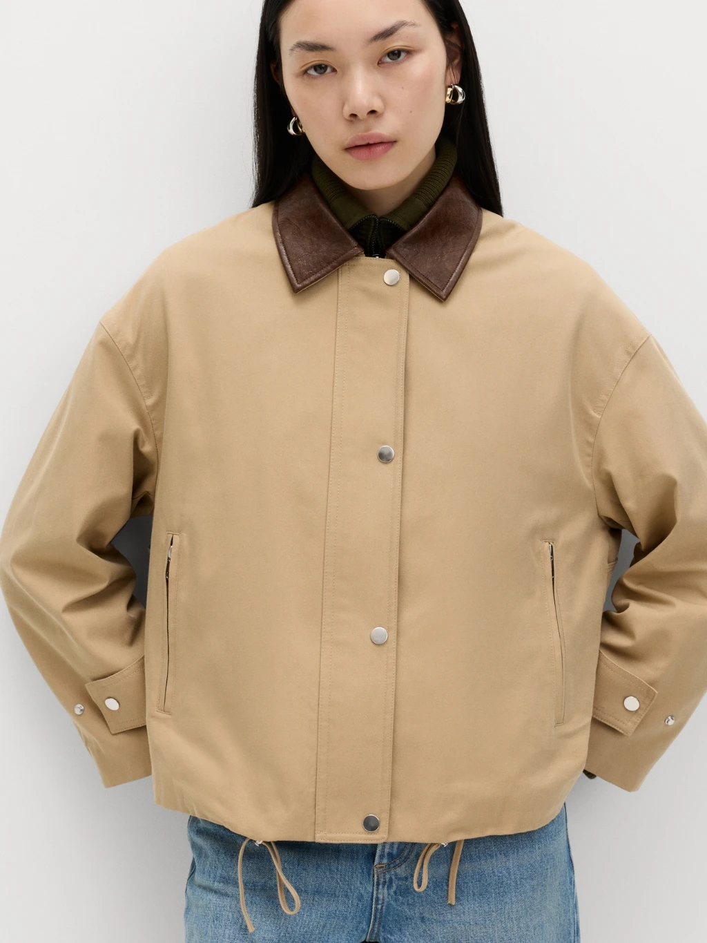 Woman wearing beige bomber jacket and jeans