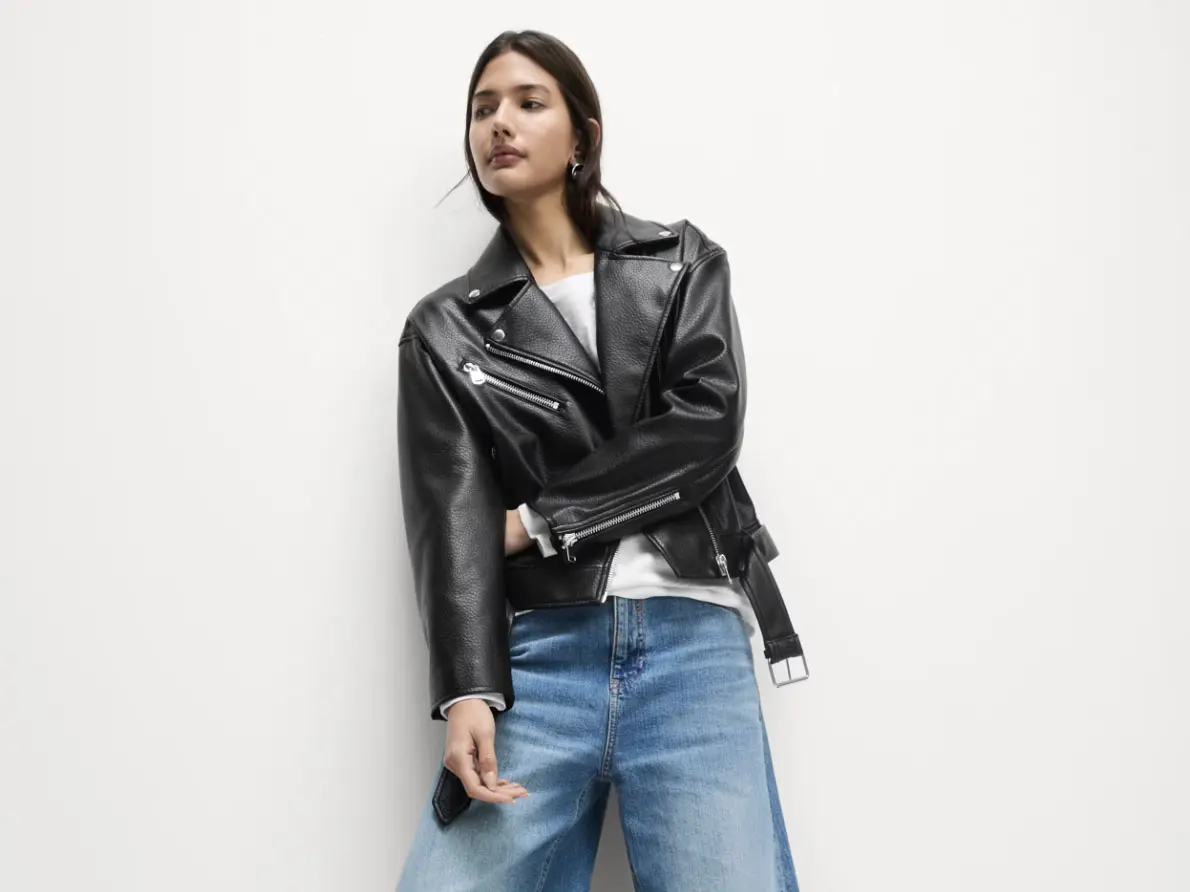 Woman wearing leather jacket over white T-shirt and blue jeans