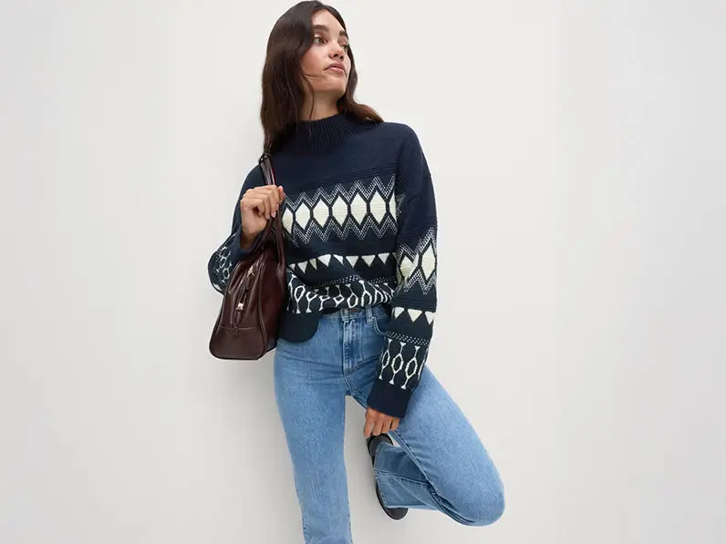 Woman wearing a Fair Isle jumper with light-wash jeans and a brown leather shoulder bag