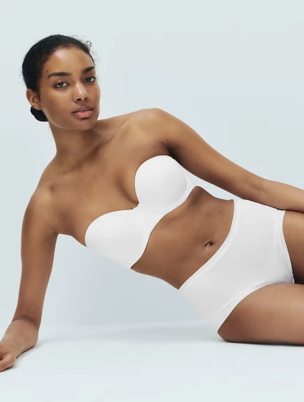 Woman wearing a white strapless bra with coordinating knickers