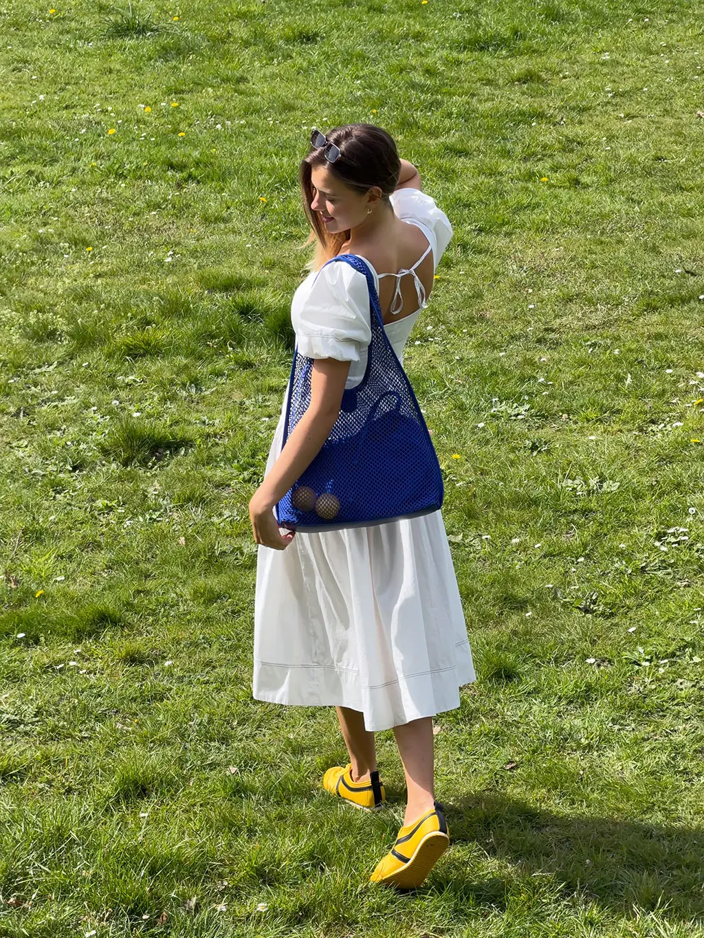 Woman in white dress with blue bag
