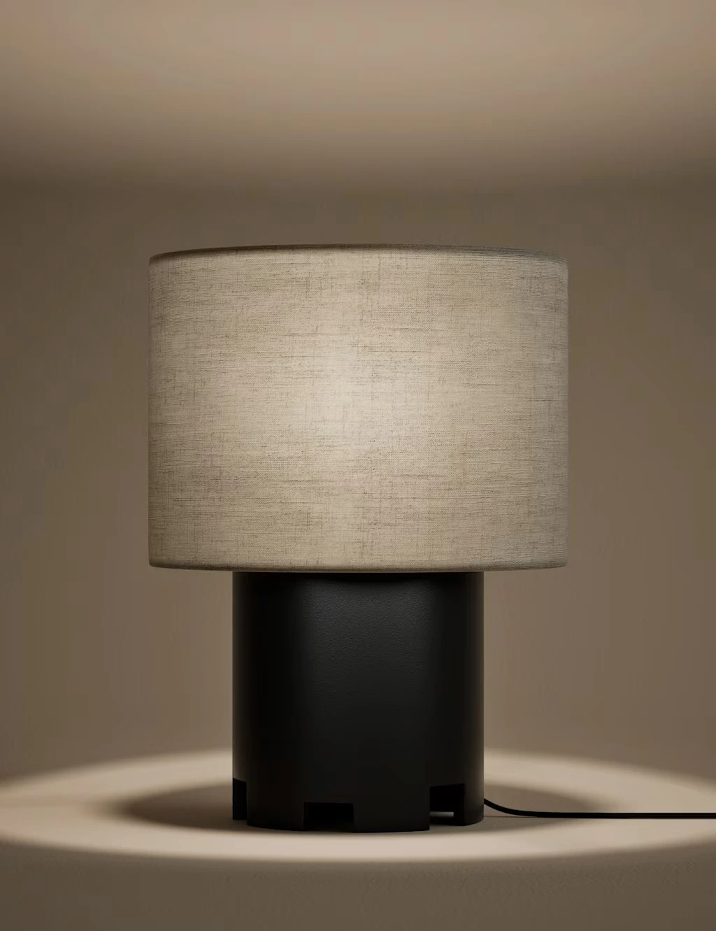 Neutral lamp with a dark round base and natural fabric shade.