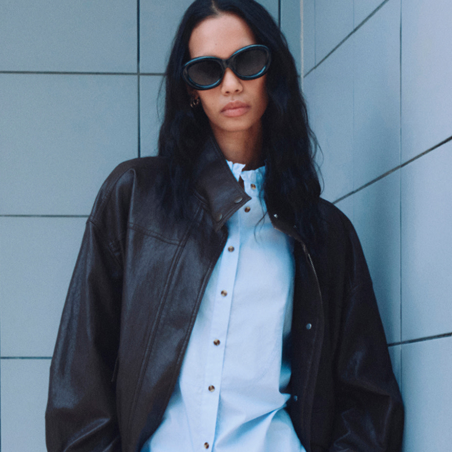 Woman wearing blue shirt under leather jacket