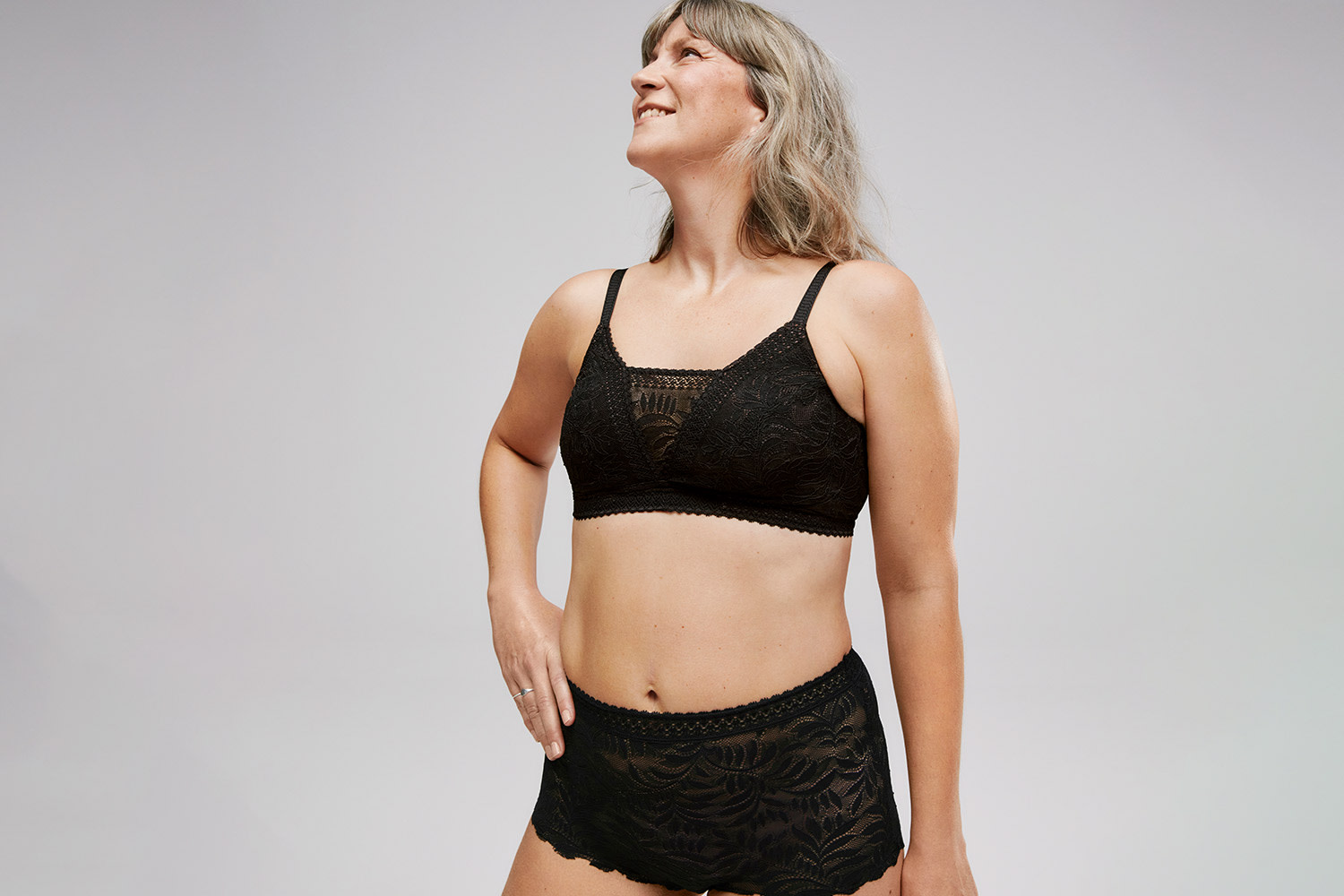 Woman wearing black lace post-surgery bra. Book a post-surgery bra fit