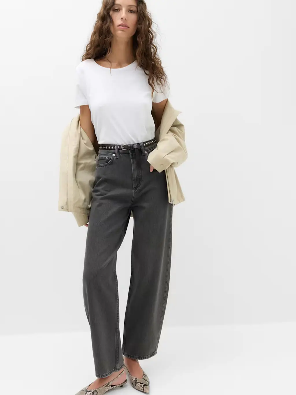Woman wearing black balloon-leg jeans with a white T-shirt, kitten heels and a short trench coat