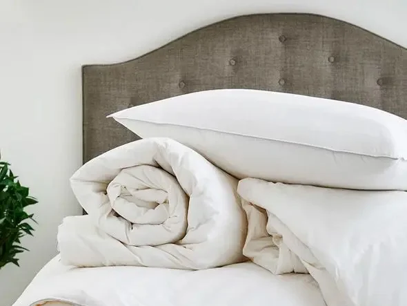 Bed made up with pillows and a quilted duvet