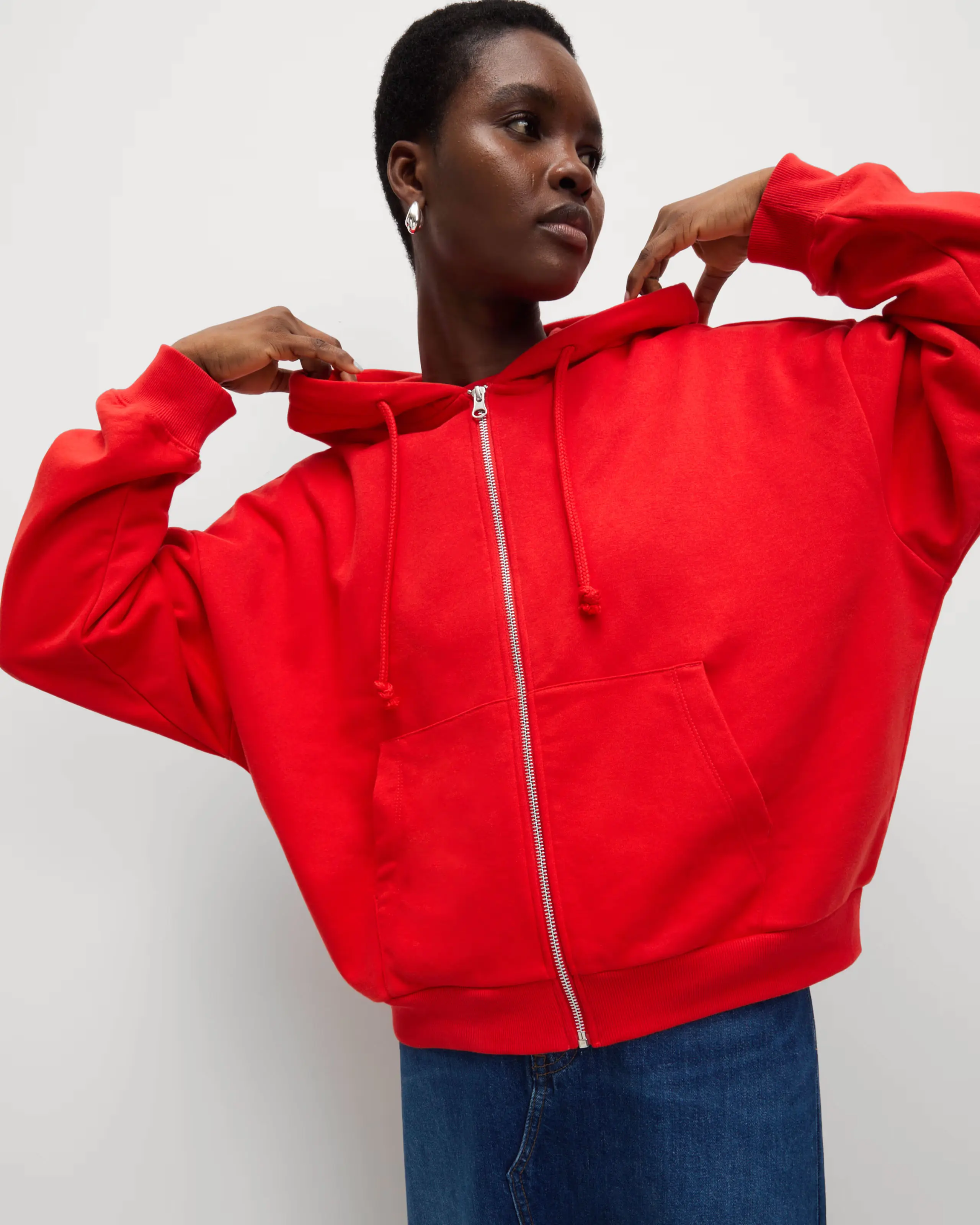 Woman wearing red hoodie and blue jeans