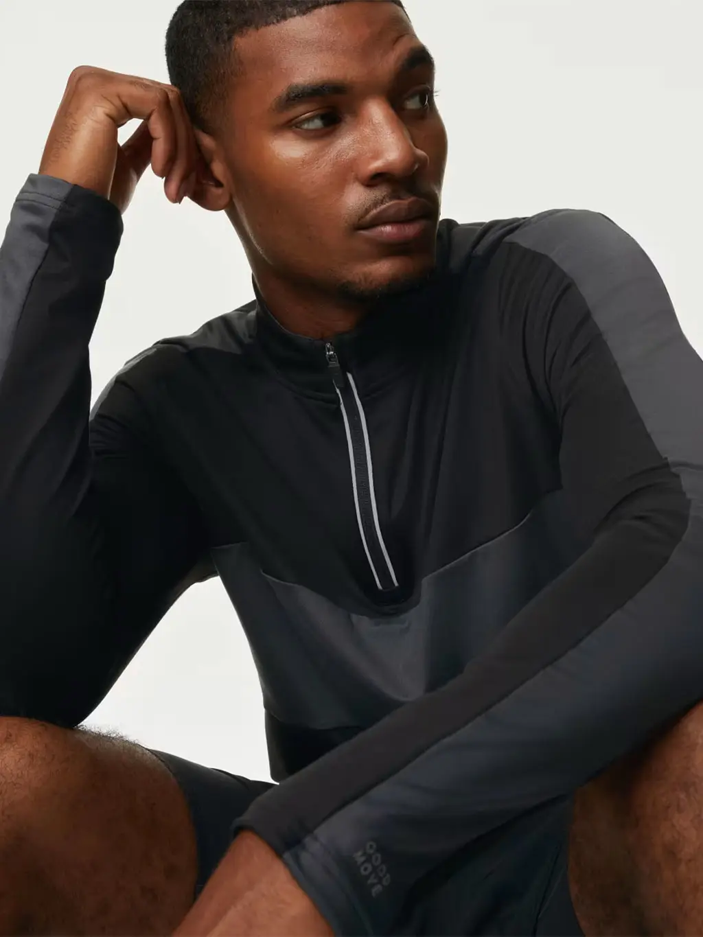 Man wearing a black quarter-zip sports top