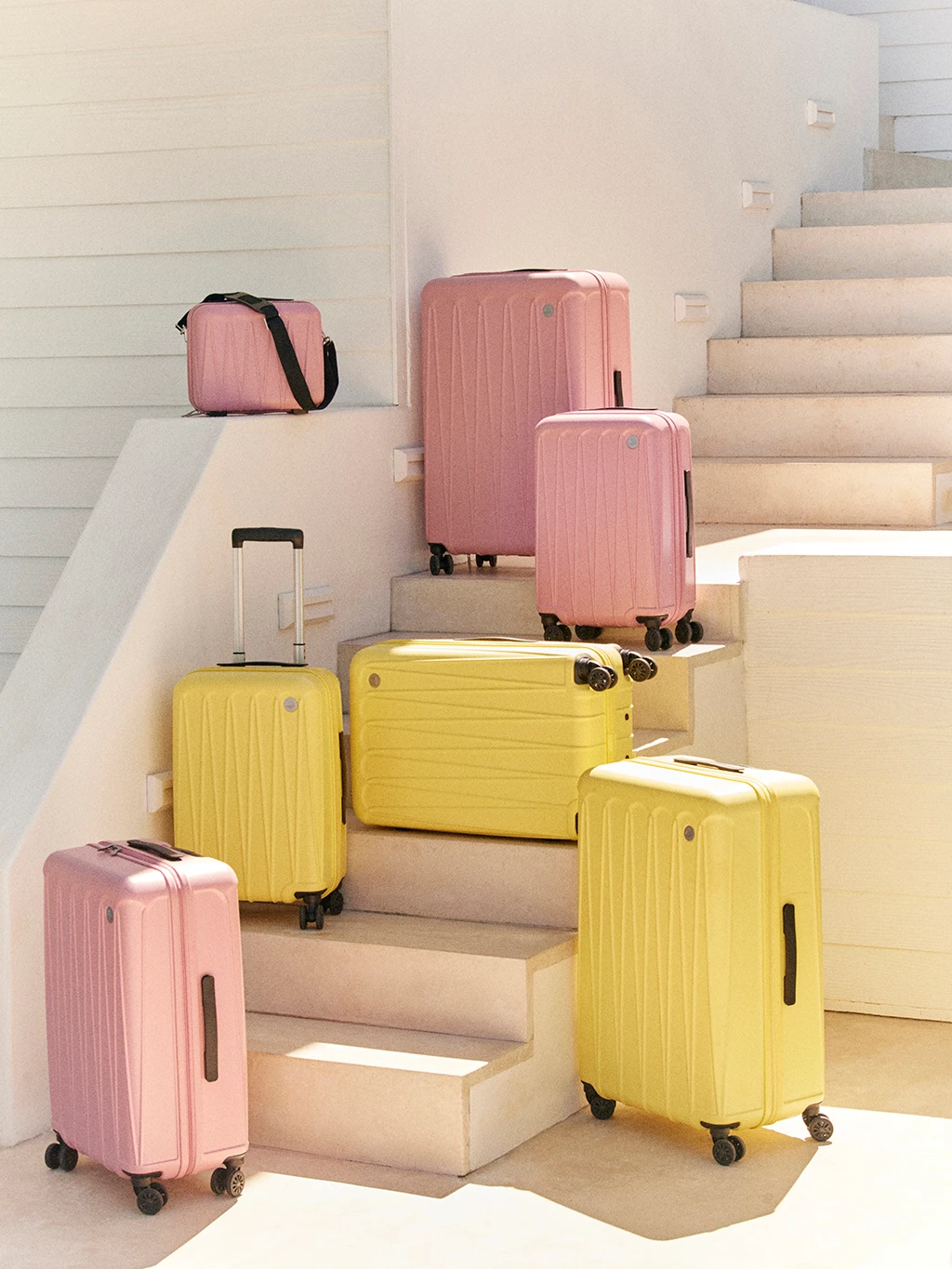 A selection of pink and yellow suitcases