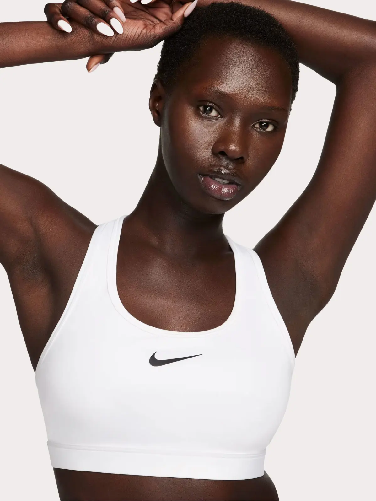 Woman wearing white sports bra with Nike logo