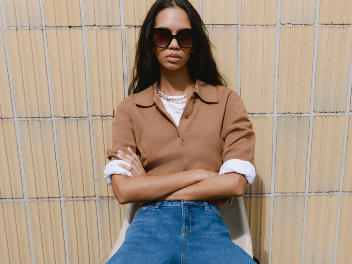 Woman wearing layered outfit with blue jeans