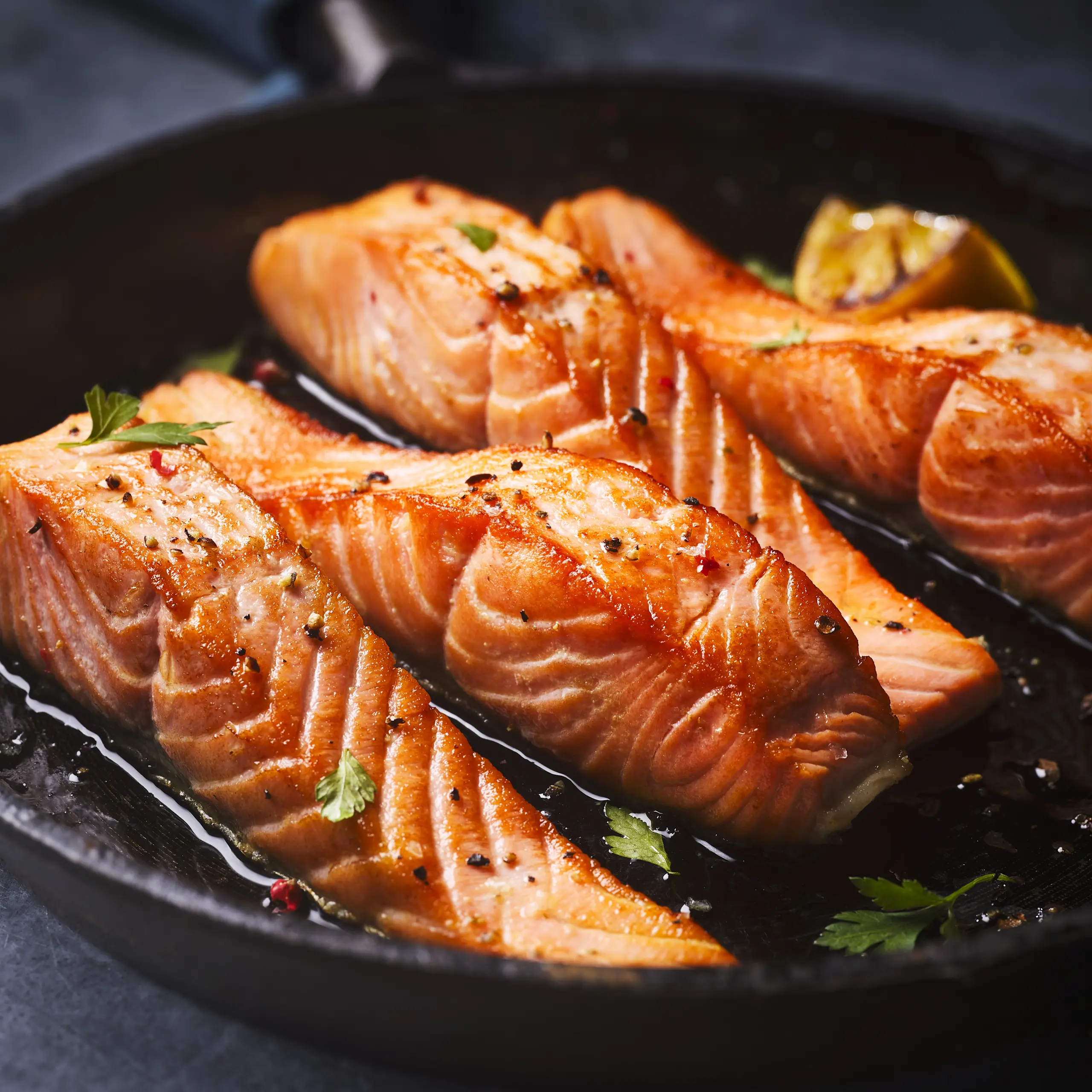 Salmon fillets cooking in pan