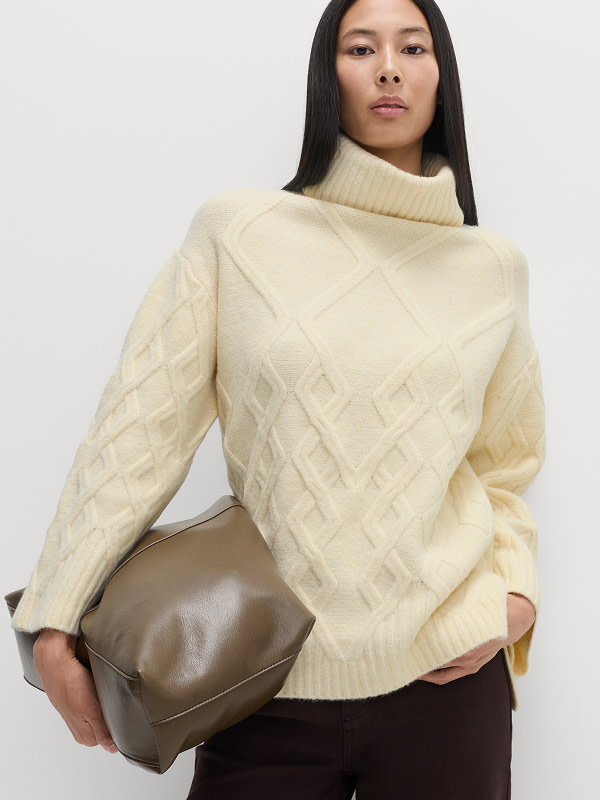 Woman wearing cream cloud-yarn roll-neck jumper