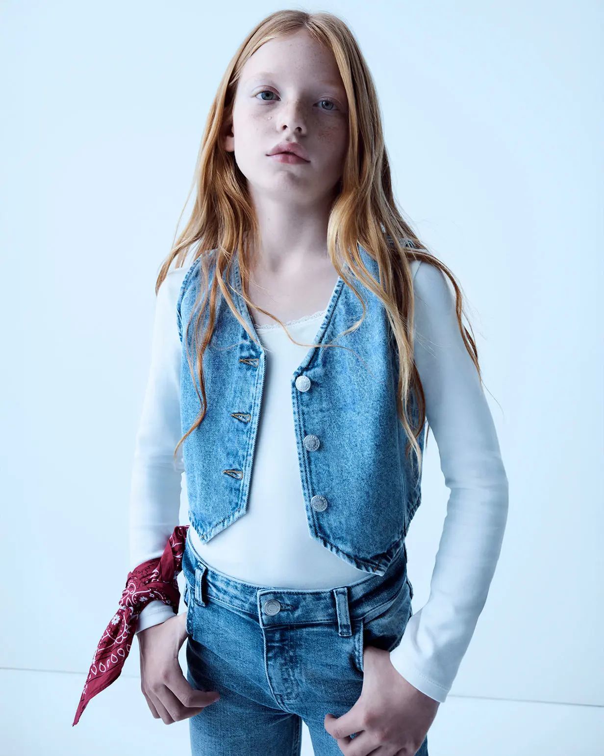 Girl wearing light blue denim jeans and a waistcoat