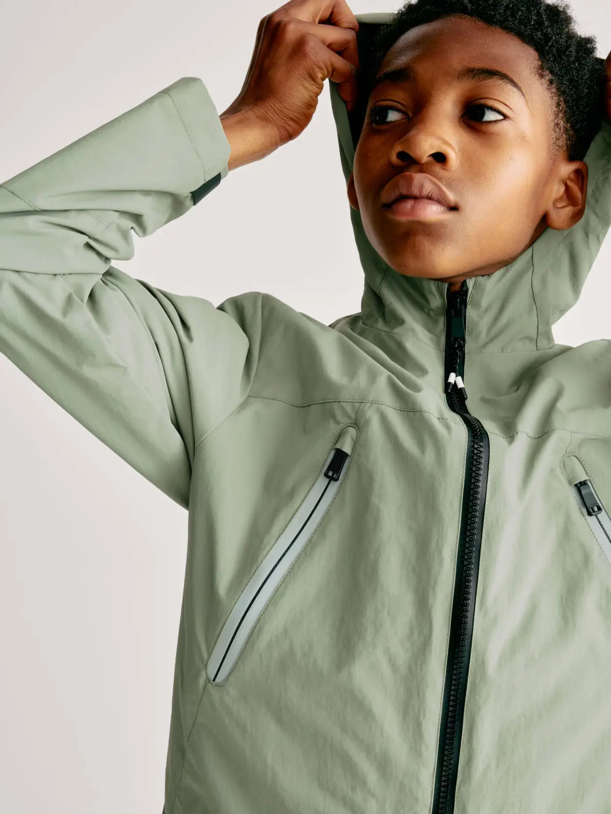 Boy wearing green hooded jacket with chest zip pockets