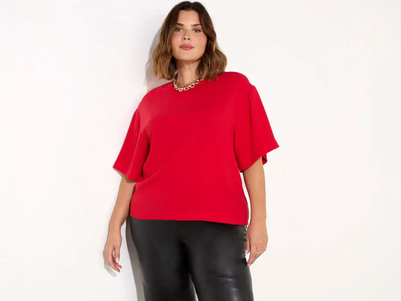 Woman wearing black leather trousers and a red top