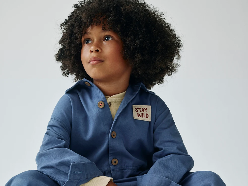 Boy wearing blue jumpsuit from the M&S x Binky collection