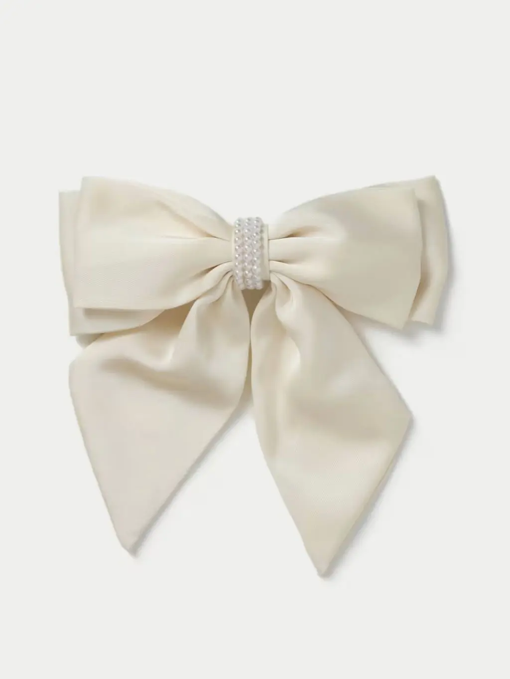 A cut out of a cream hair bow on a cream background