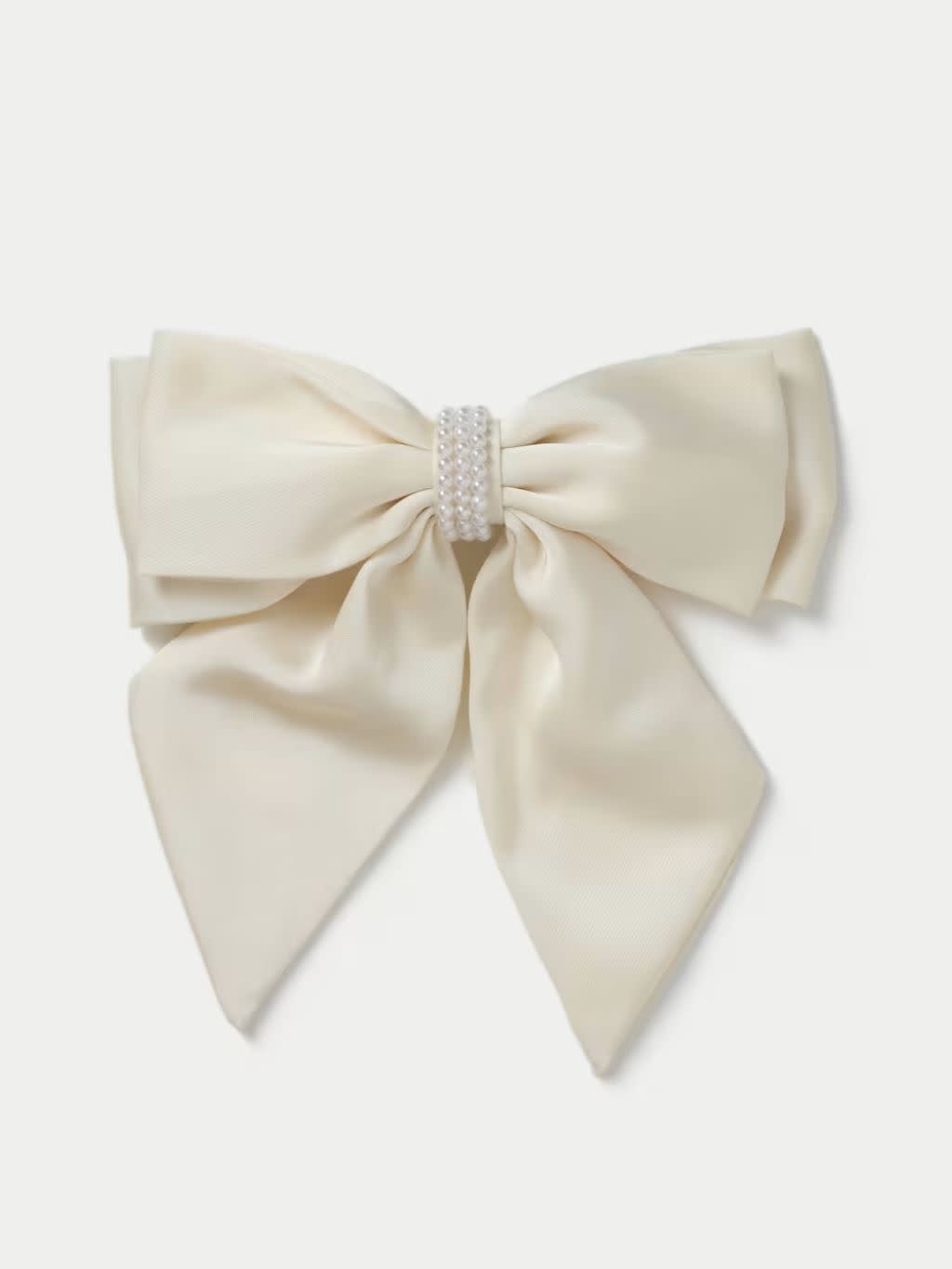A cut out of a cream hair bow on a cream background
