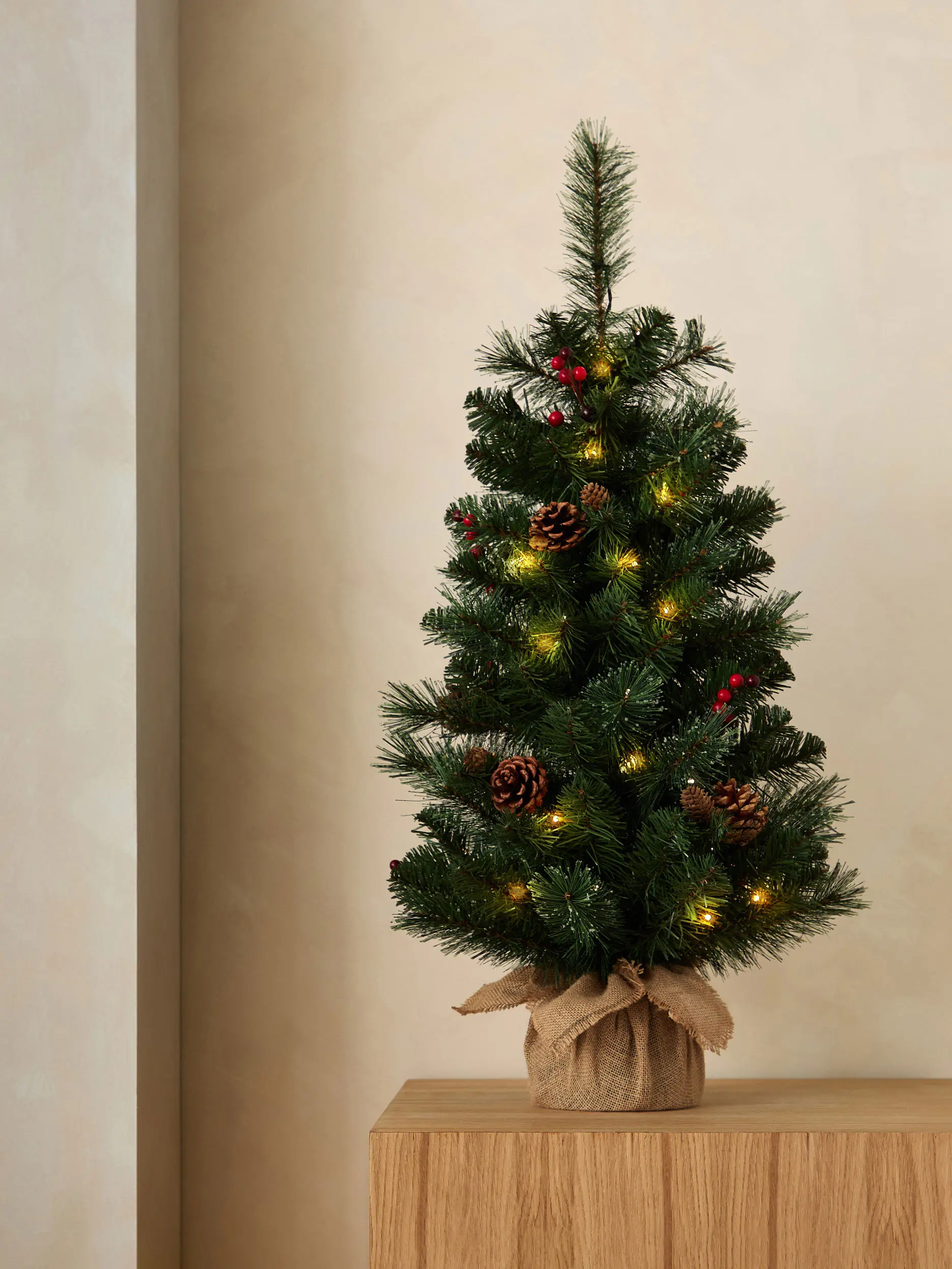 Image of Christmas tree with pine cones, lights and red berries