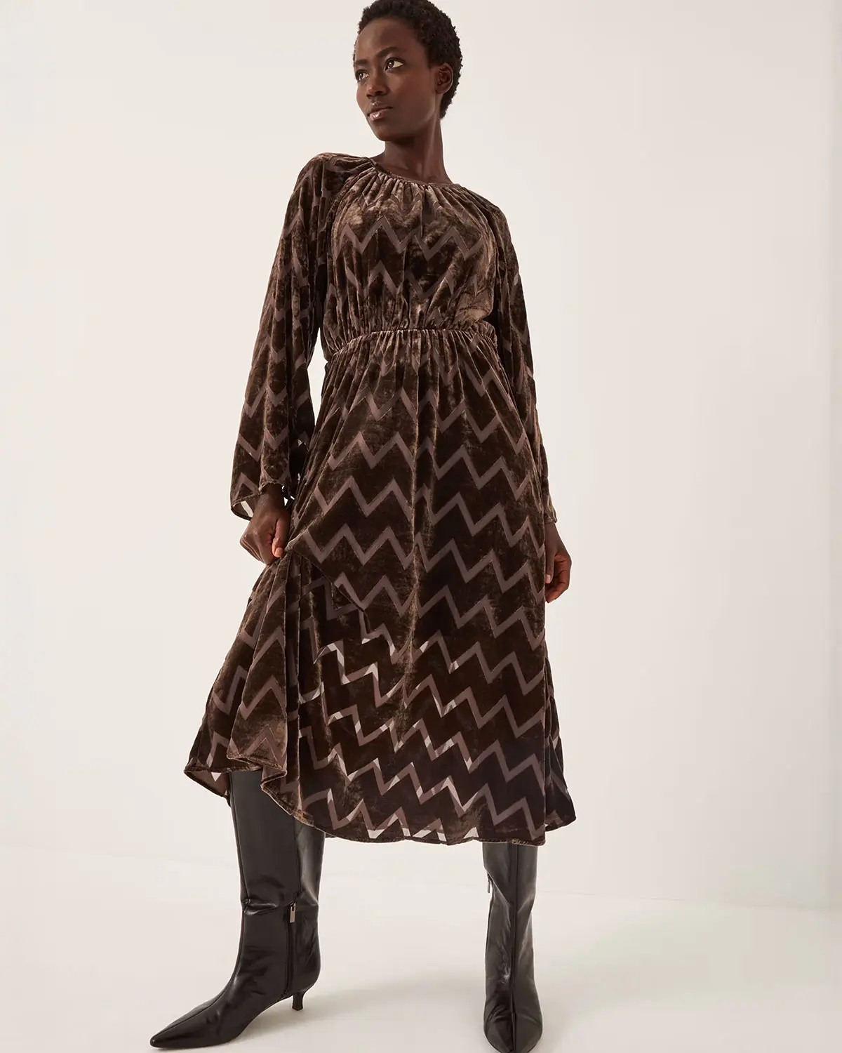 Woman wearing brown velvet dress by Monsoon