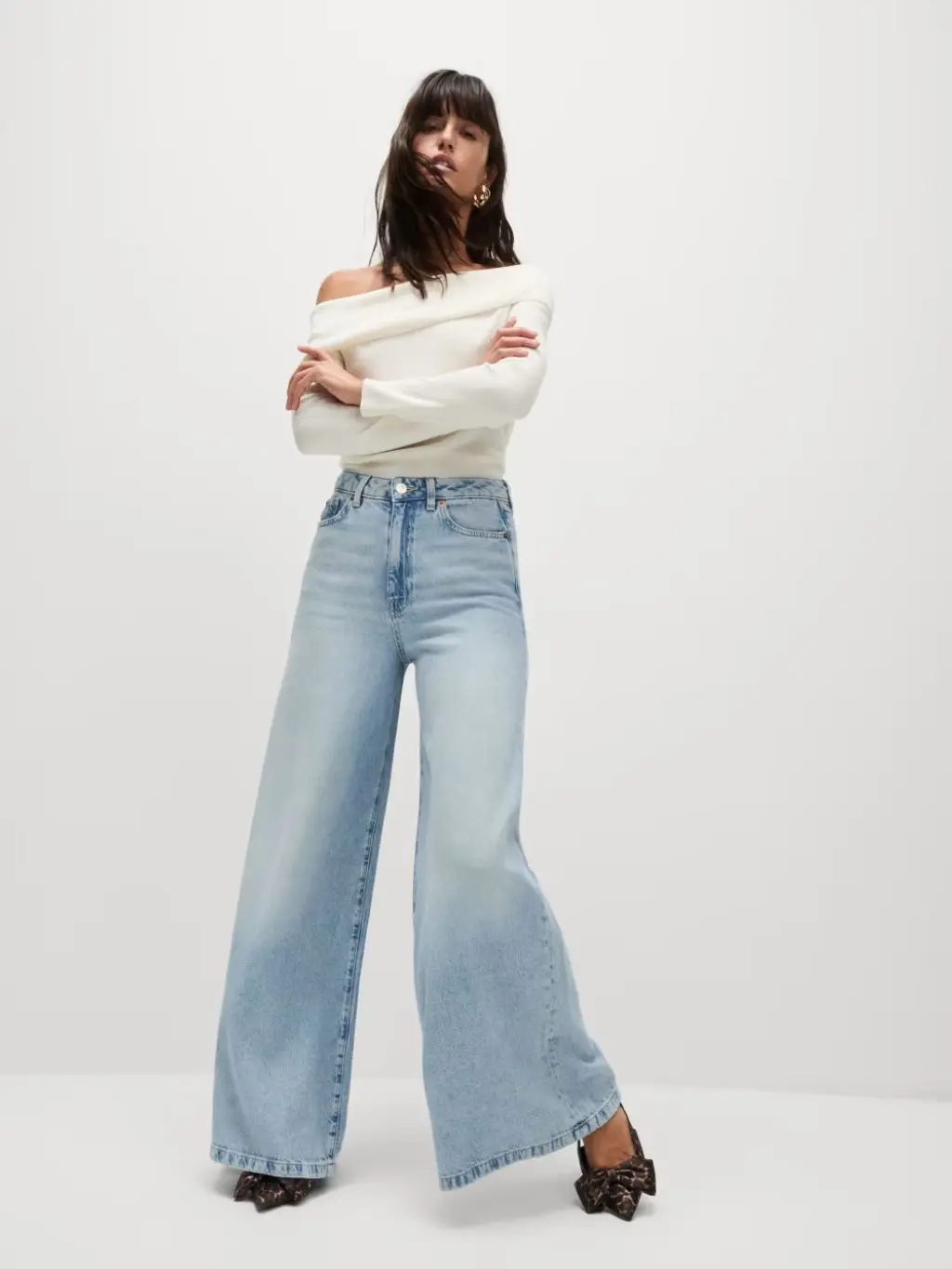 A woman wears pale blue wide leg jeans
