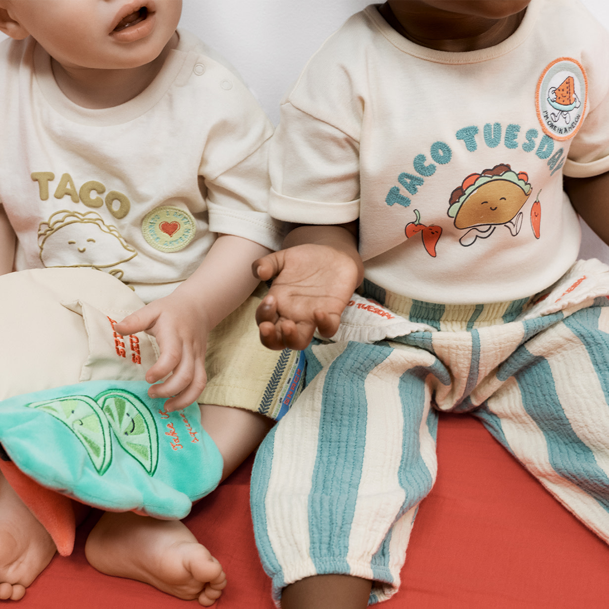 close up image of two babies wearing taco tuesday outfits