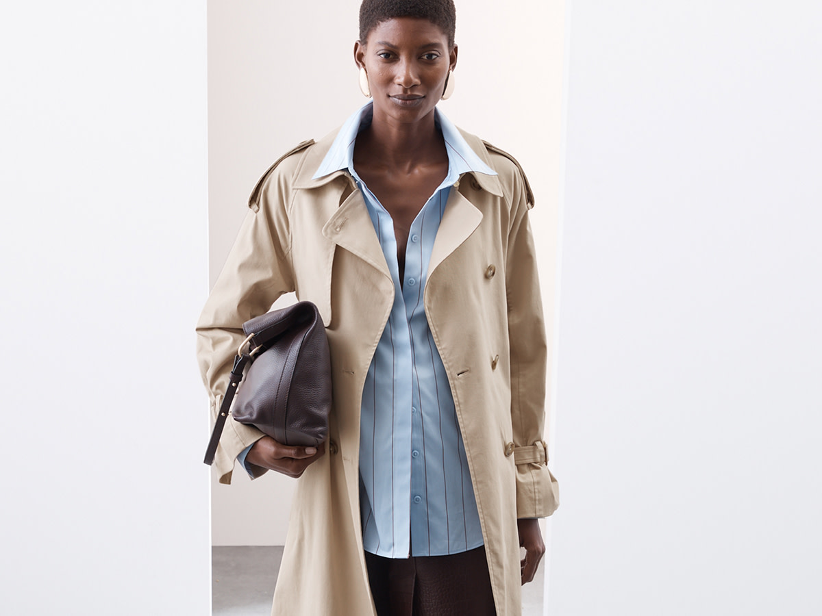 Woman wearing trench coat and blue shirt