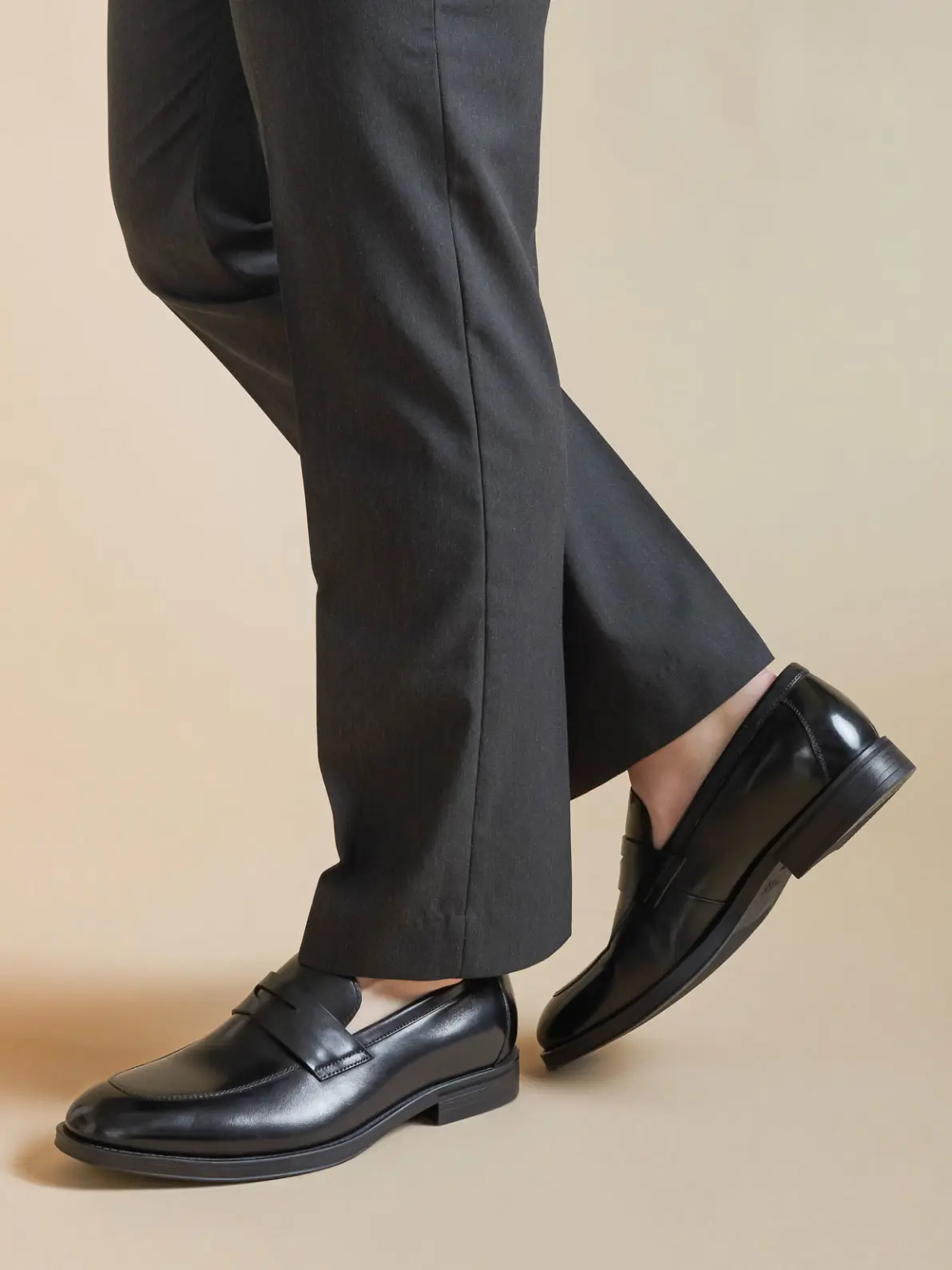 Man wearing smart suit trousers and black leather loafers