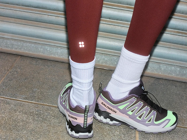 Woman wearing grey and neon green running trainers with white socks