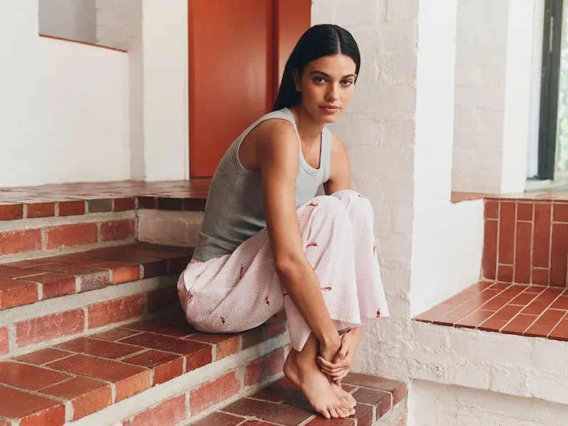 woman wearing a grey tank top and pink patterned pyjamas
