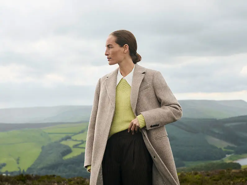 Woman in wool coat with green jumper