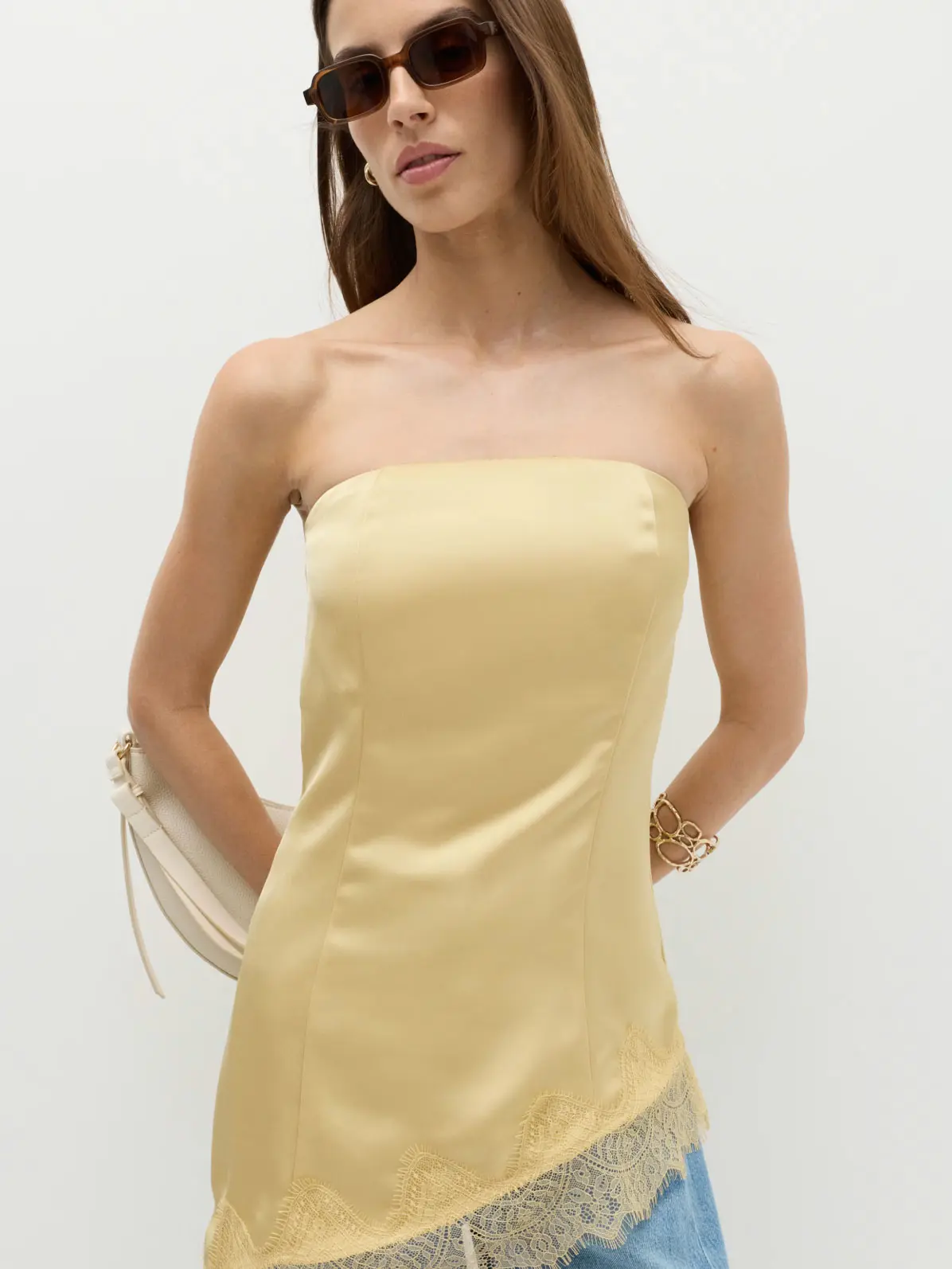 Woman wearing yellow asymmetrical top and sunglasses 
