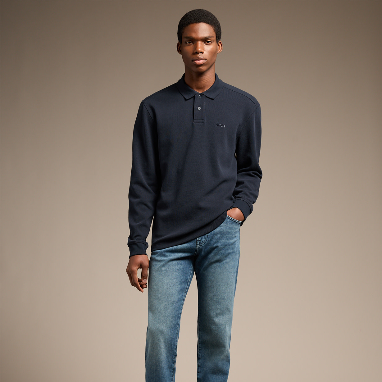 man wearing navy rugby top and jeans