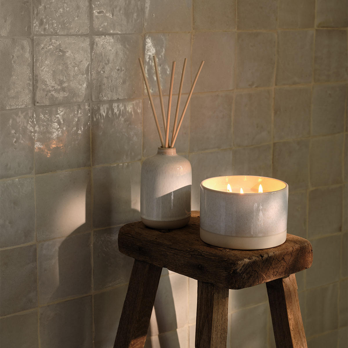 Candle and diffuser on wooden stool