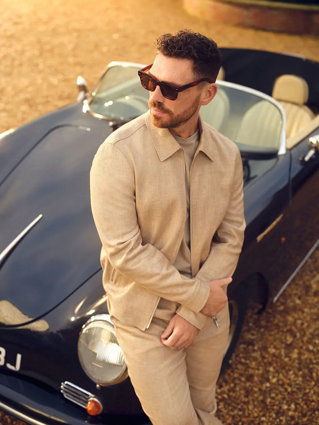 James Nelson Joyce in tan linen bomber jacket and trousers